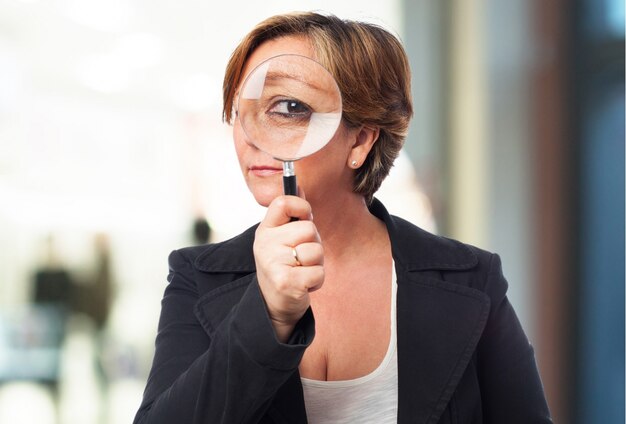 Vieille femme avec une loupe