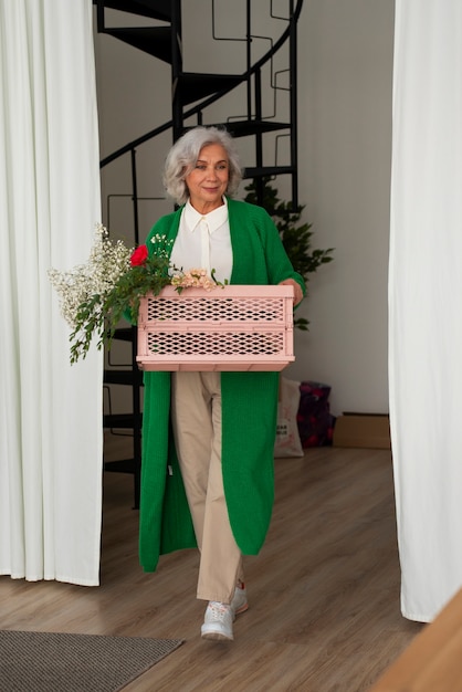 Une vieille femme qui s'occupe des plantes.