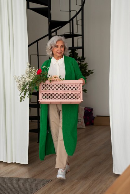 Une vieille femme qui s'occupe des plantes.