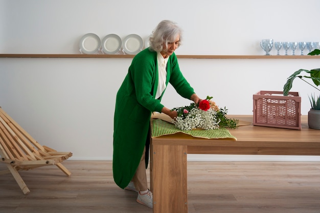 Une vieille femme qui s'occupe des plantes.