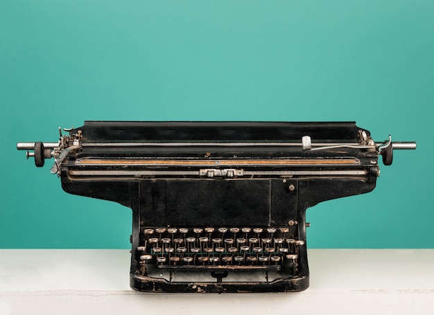 Vieille machine à écrire rétro avec du papier sur la table en bois