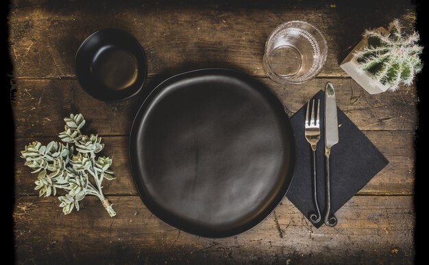 Vieille table en bois avec des plats et des décorations sous les lumières