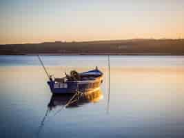 Photo gratuite vieux bateau de pêche à la rivière avec la vue imprenable sur le coucher du soleil