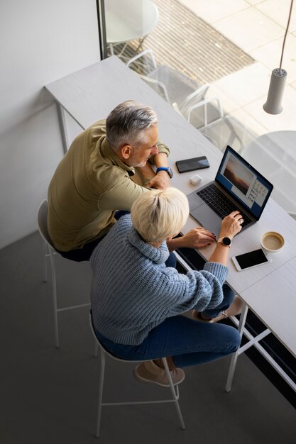 Vieux couple apprenant à utiliser la technologie