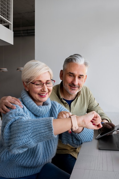 Vieux couple apprenant à utiliser la technologie