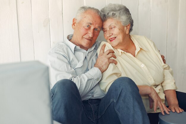 Vieux couple élégant assis à la maison sur un plancher