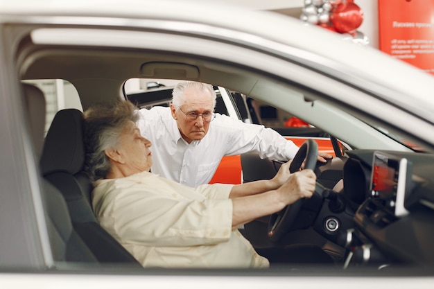 Vieux couple élégant dans un salon de voiture