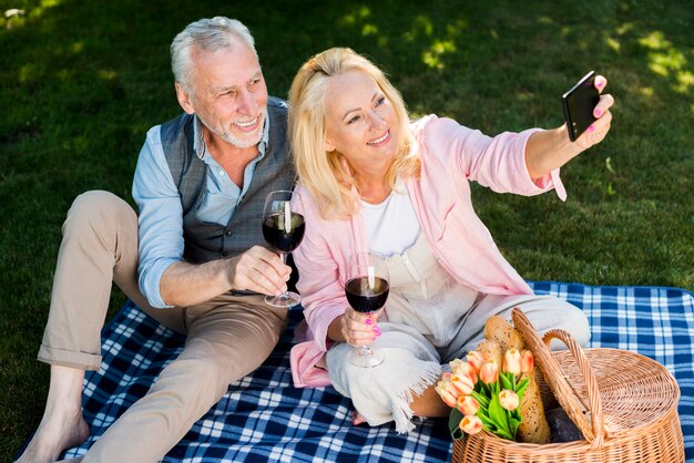 Vieux couple prenant un selfie en hauteur