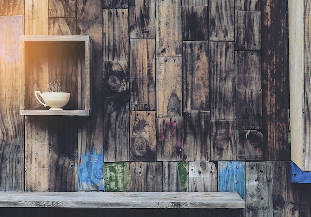 Vieux fond de mur en bois avec étagères et vieille tasse à café