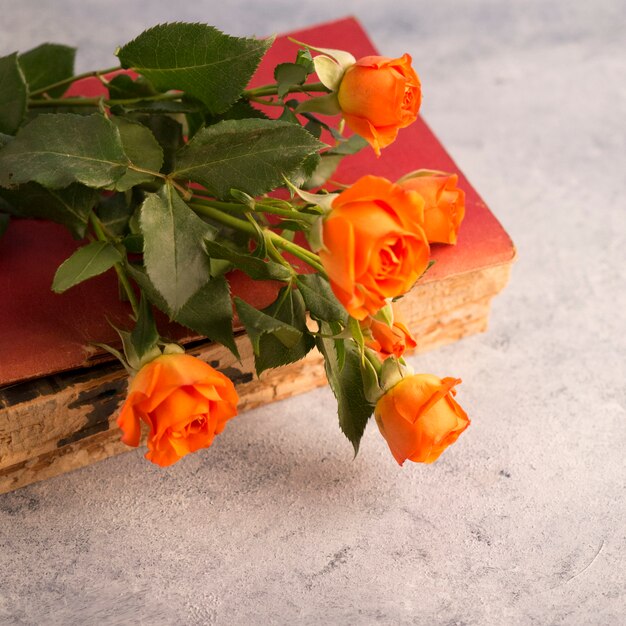 Vieux livre et bouquet de fleurs sur une surface minable