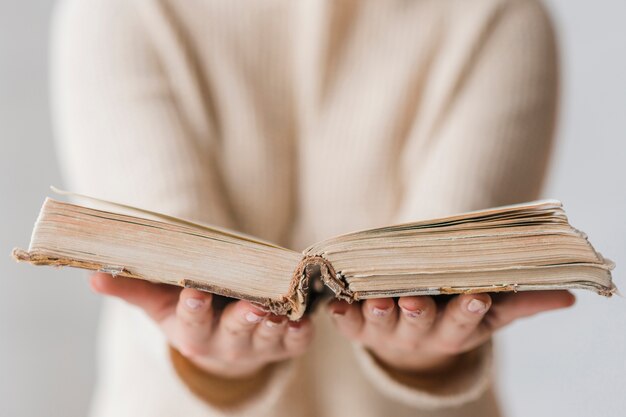 Un vieux livre ouvert dans la main de la femme