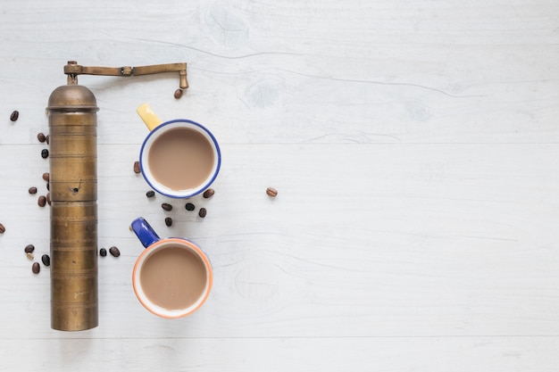 Photo gratuite vieux moulin à café et grains de café avec du café chaud sur fond en bois