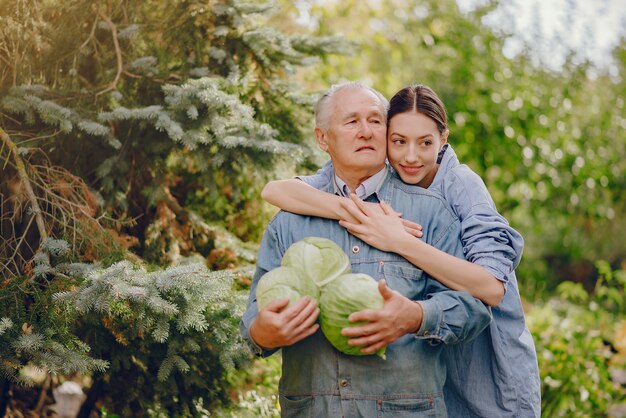 Vieux senior debout dans un jardin d'été avec du chou