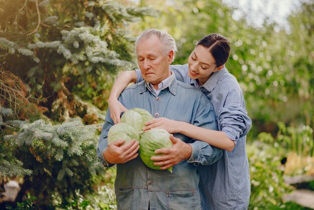 Vieux senior debout dans un jardin d'été avec du chou