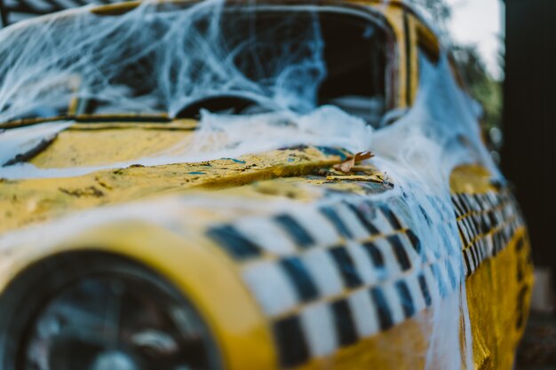 Vieux taxi jaune rétro décoré de toiles d'araignées