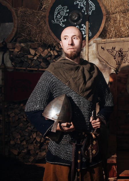 Photo gratuite viking posant contre l'ancien intérieur des vikings.