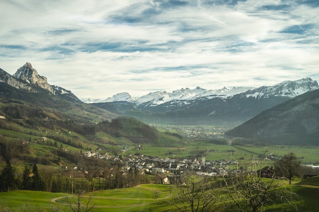 Village dans une belle vallée avec des montagnes couvertes de neige