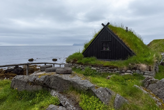 Photo gratuite village de pêcheurs islandais typique avec maisons au toit d'herbe et séchoirs à poisson