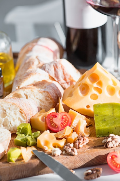 Vin, baguette et fromage sur table en bois