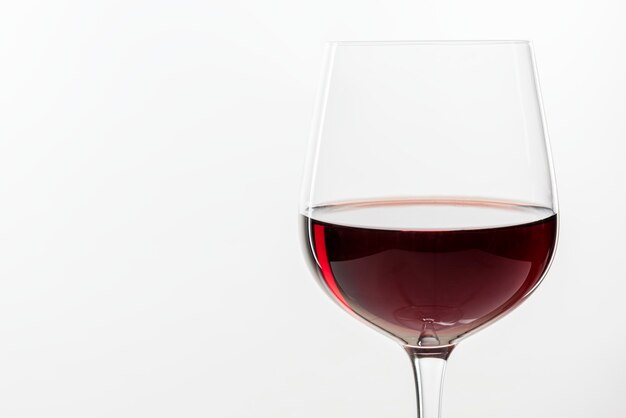Vin rouge dans un verre sur fond blanc