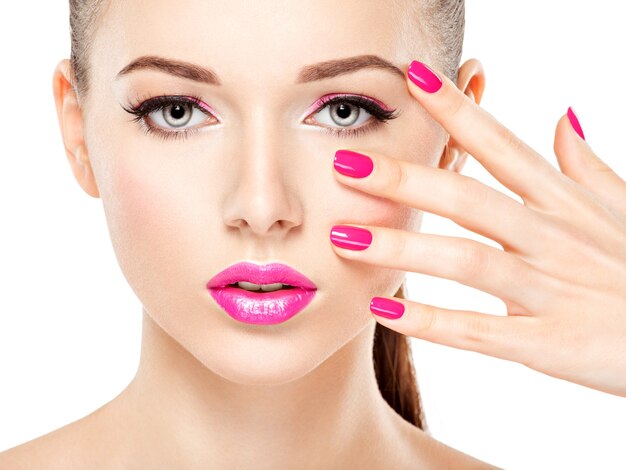 Visage de belle femme avec maquillage rose des yeux et des ongles. Portrait de mannequin glamour