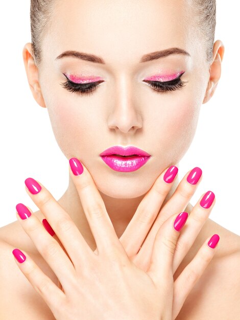 Visage de belle femme avec maquillage rose des yeux et des ongles. Portrait de mannequin glamour