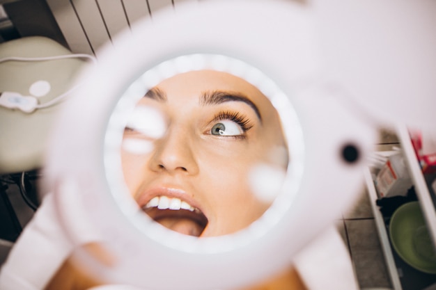 Visage féminin à travers la loupe dans un salon de beauté