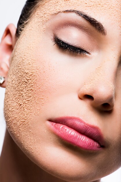 Visage d'une femme avec de la poudre cosmétique sur la peau