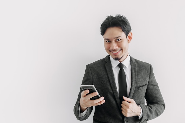 Visage de sourire heureux d'homme d'affaires utilise un smartphone