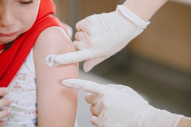 Visite médicale de petit enfant. Médecin donnant une injection à l'enfant dans le bras.