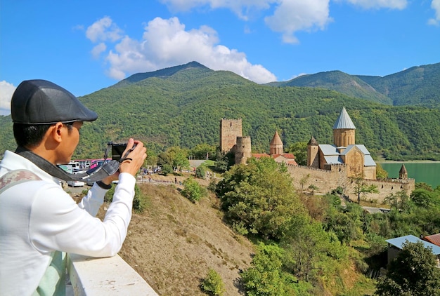 Visiteur prenant des photos du complexe du château médiéval d'ananuri, un monument célèbre sur la rive de la rivière aragvi, géorgie