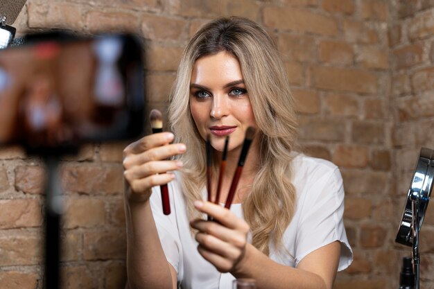 Vlogger de beauté faisant une vidéo avec des cosmétiques