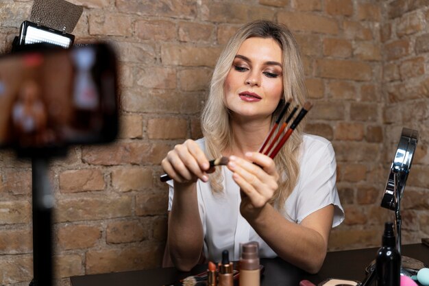 Vlogger de beauté faisant une vidéo avec des cosmétiques