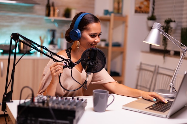 Photo gratuite vlogger parlant avec un suiveur en direct à l'aide d'un microphone professionnel portant des écouteurs. émission en ligne créative hôte de diffusion internet de production en direct diffusant du contenu en direct et enregistrement