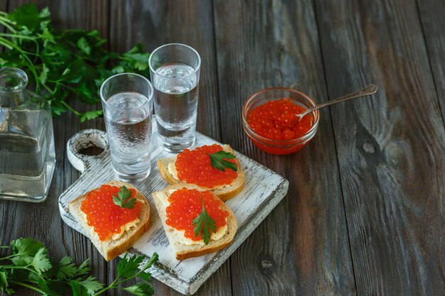 Vodka au caviar de saumon et pain grillé sur table en bois