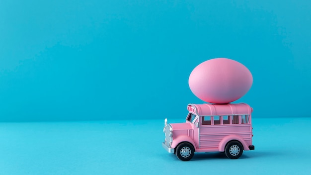 Voiture de pâques rose avec oeuf et espace de copie