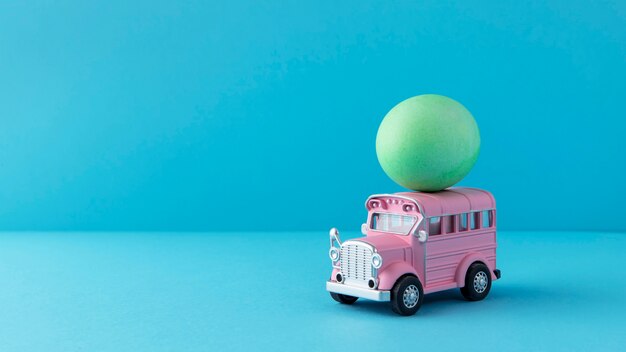 Voiture de Pâques rose avec oeuf vert nature morte