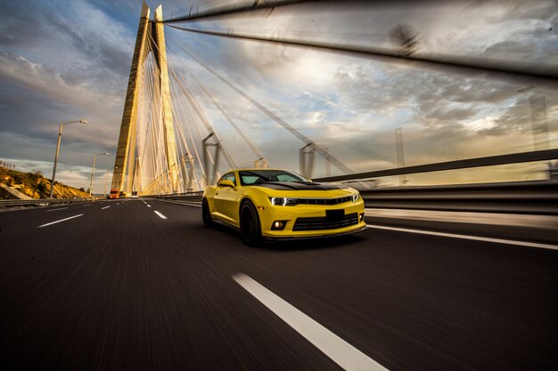 Voiture de sport jaune avec réglage automatique noir sur le pont.