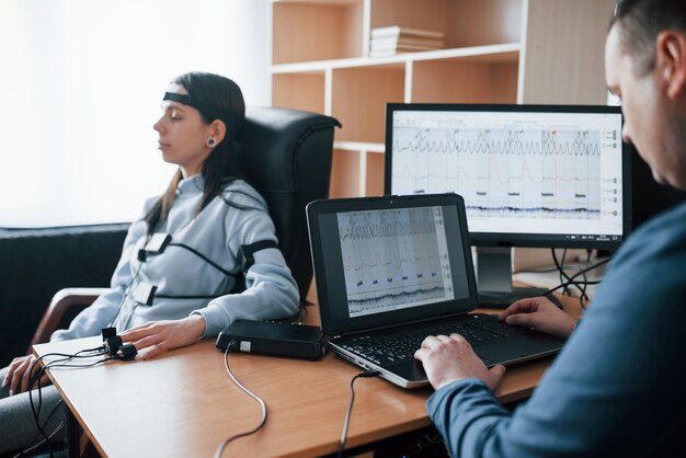 Vol de jeune femme. La fille passe le détecteur de mensonge dans le bureau. Poser des questions. Test polygraphique