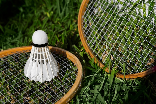 Photo gratuite volant et raquettes de badminton sur l'herbe