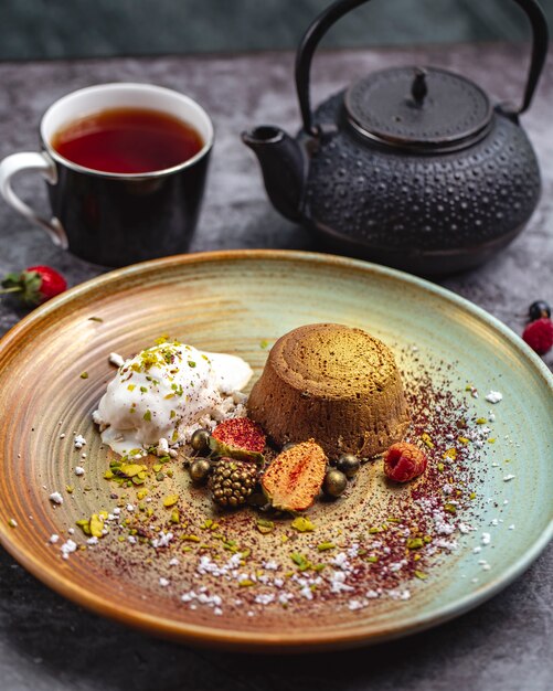 Volcan chocolat teinté doré servi avec glace vanille et baies et thé