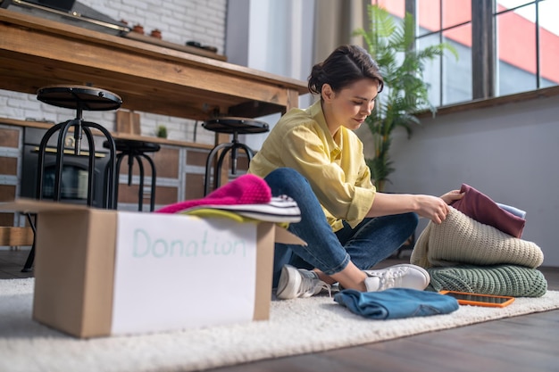 Volontaire heureux de choisir des vêtements à donner