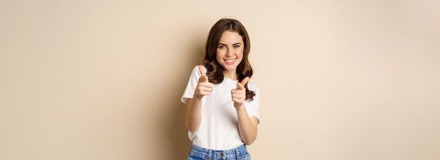 Photo gratuite vous avez cette félicitations jeune femme souriante pointant du doigt la caméra applaudissant complimentant debout