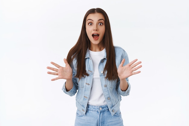 Vous n'allez jamais le croire. Fille brune excitée étonnée et impressionnée, levant les mains et la bouche ouverte, fascinée de raconter à quelqu'un des nouvelles incroyables, souriante, étonnée et étonnée