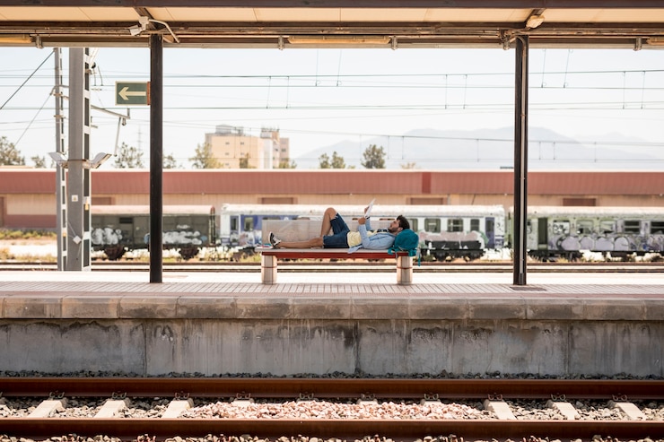 Photo gratuit voyageur allongé sur le banc en attente du train