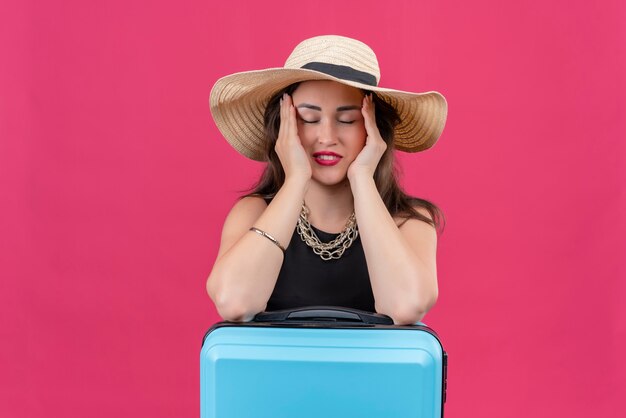 Voyageur Fatigué Jeune Fille Portant Un Maillot De Corps Noir Au Chapeau A Mis Ses Mains Sur Les Joues Sur Fond Rouge