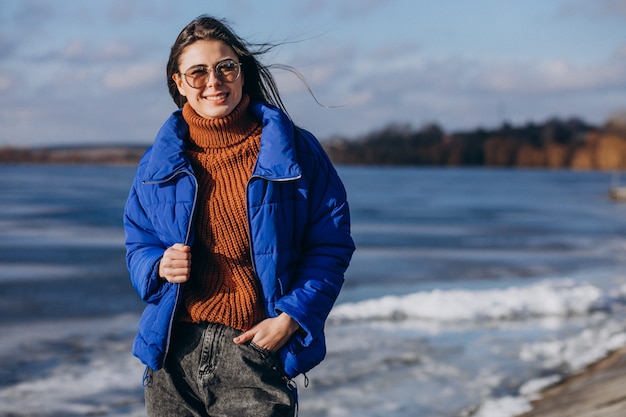 Voyageur de la jeune femme en veste bleue sur la plage