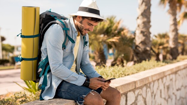 Voyageur latéral regardant téléphone