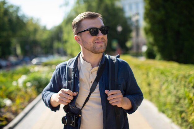 Voyageur masculin avec un appareil photo dans un parc local