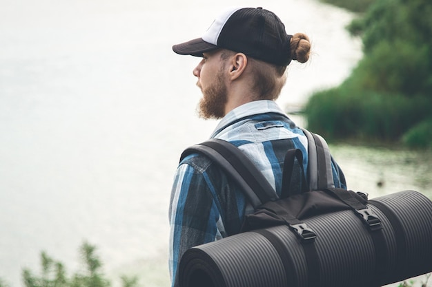 Photo gratuite voyageur masculin avec sac à dos et karimat dans la nature vue arrière